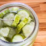 A fork spearing two slices of quick, refrigerator dill pickles.