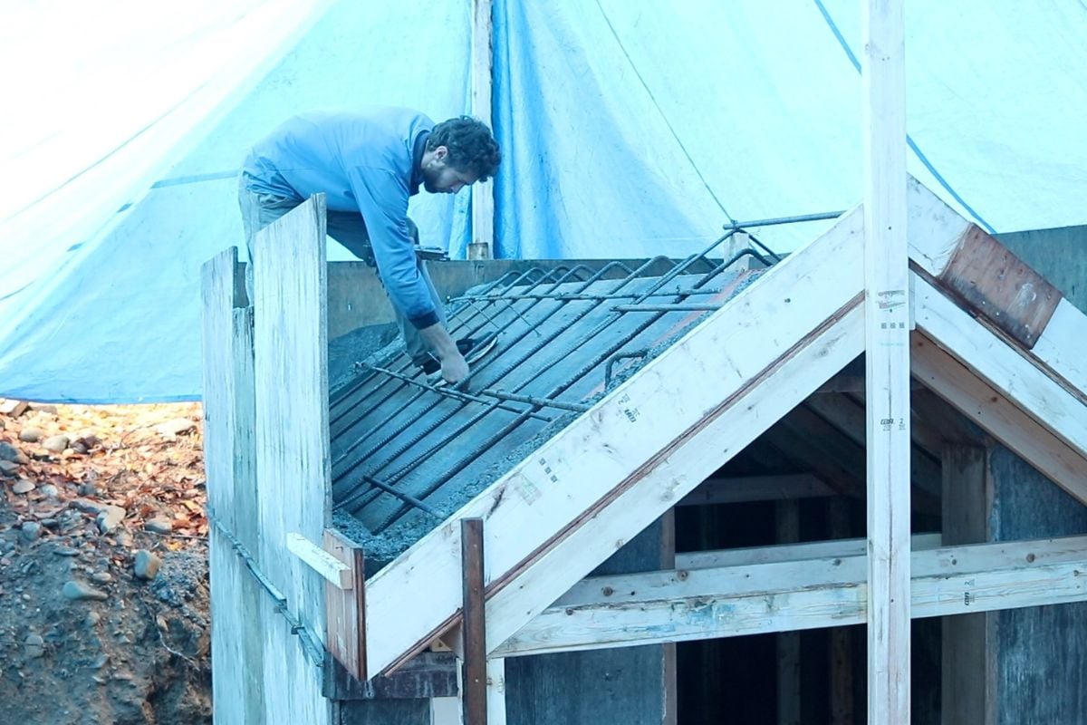 A man setting rebar and quick strip ties into the forms for the concrete roof.