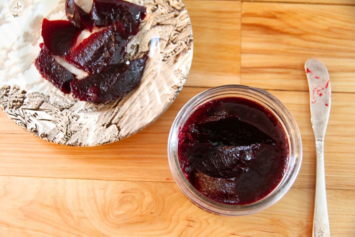 An opened jar of home canned blackberry jelly.