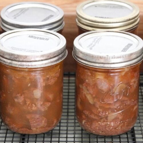 Canned jars of bear meat, cooking on a kitchen counter.