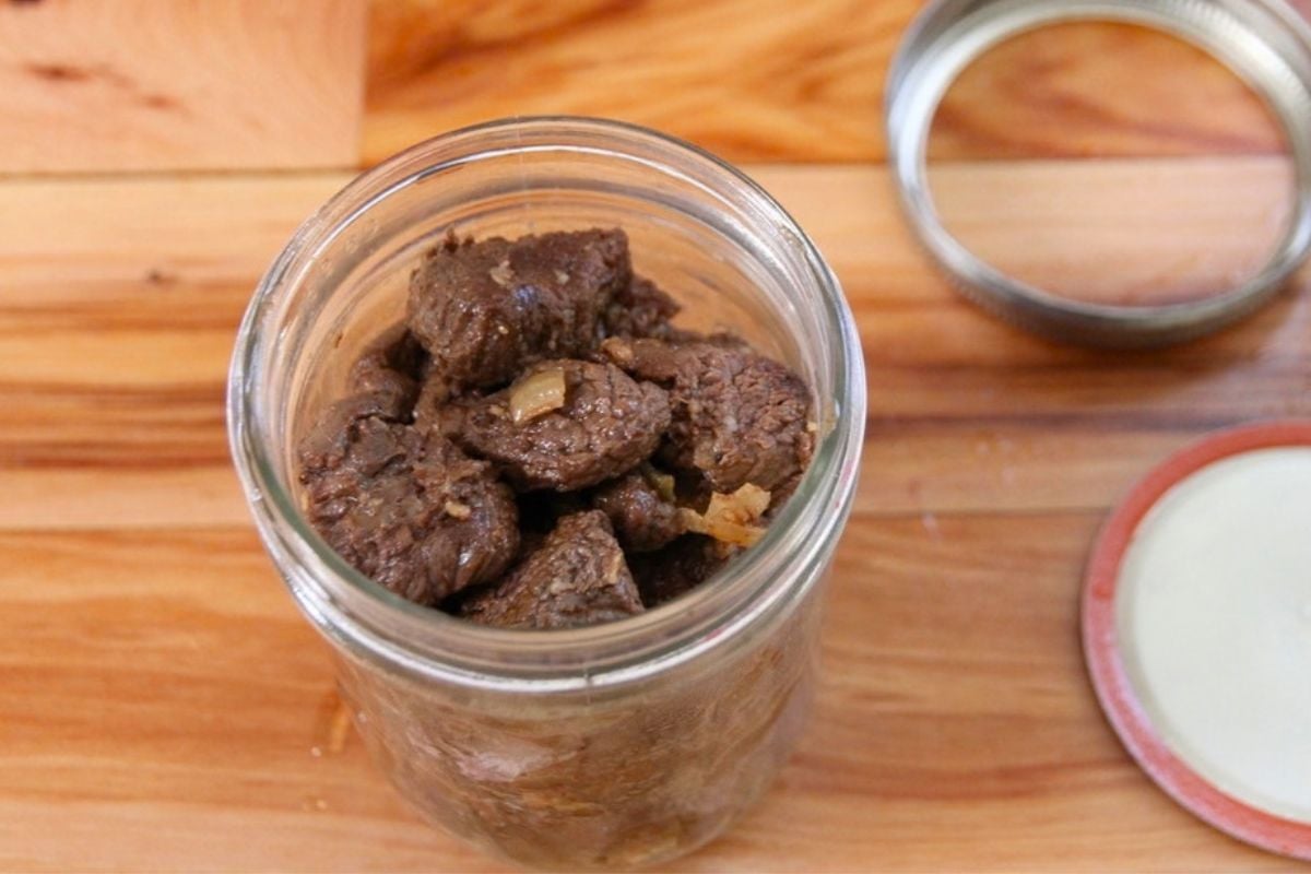 A jar filled with seared bear meat, ready for canning.